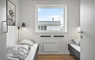 a bedroom with a bed and a window at Nice Home In Harboøre With Sauna in Harboør