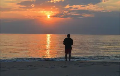 a man standing on the beach watching the sunset at Nice Home In Harboøre With Sauna in Harboør