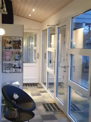 a room with a door and a chair next to a window at Bente's Guesthouse in Holstebro