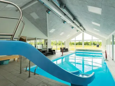 a swimming pool with a slide in a building at 15 person holiday home in Højslev in Højslev