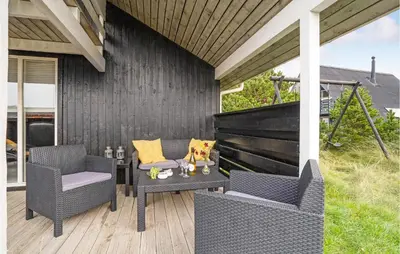 a patio with two wicker chairs and a table at Gorgeous Home In Thisted With Sauna in Thisted