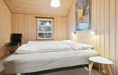 a large bed in a room with wooden walls at Gorgeous Home In Thisted With Sauna in Thisted