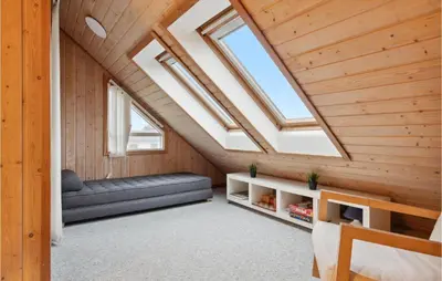 an attic room with a couch and skylights at Gorgeous Home In Thisted With Sauna in Thisted