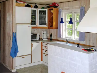 a kitchen with a white refrigerator and a sink at Secluded Forest Retreat at Gjol-By Traum in Åbybro