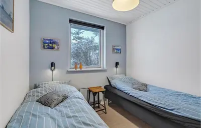 two beds in a room with a window at Nice Home In Thisted With Sauna in Thisted