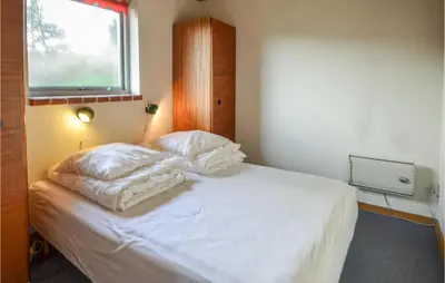 a bedroom with a bed with white sheets and a window at 2 Bedroom Beautiful Home In Fur in Fur