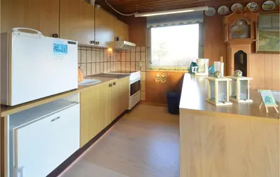 a kitchen with wooden cabinets and a white refrigerator at 2 Bedroom Beautiful Home In Fur in Fur