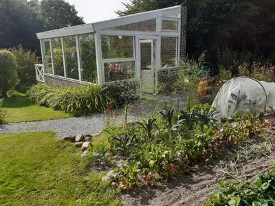 a greenhouse in the middle of a garden at Brovst bed and breakfast in Brovst