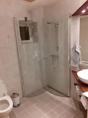 a bathroom with a shower and a toilet and a sink at Brovst bed and breakfast in Brovst