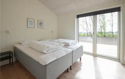 a bedroom with two beds and a large window at 4 Bedroom Cozy Home In Spøttrup in Spottrup