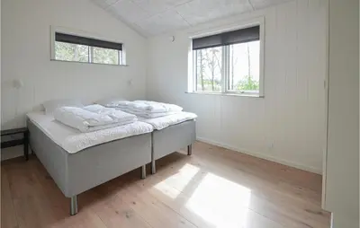 a white room with a bed and two windows at 4 Bedroom Cozy Home In Spøttrup in Spottrup