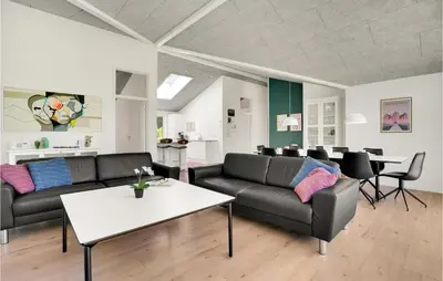 a living room with two couches and a table at 4 Bedroom Cozy Home In Spøttrup in Spottrup