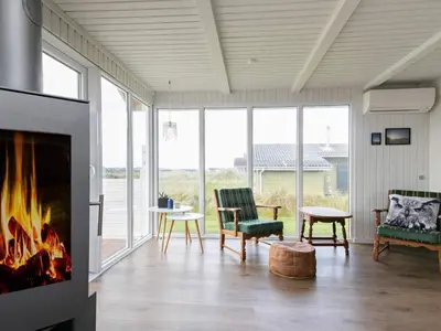a living room with a fireplace and a couch and chairs at 6 person holiday home in Thisted in Torsted