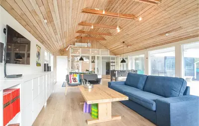 a living room with a blue couch and a table at 4 Bedroom Beautiful Home In Vestervig in Vestervig