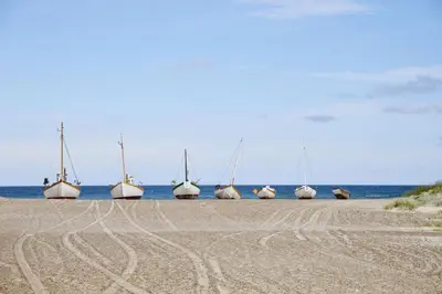 a group of boats sitting on the beach at Hotel Nor - Badehotellet in Fjerritslev