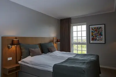 a bedroom with a large bed and a window at Hotel Nor - Badehotellet in Fjerritslev