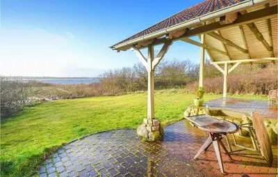 a pavilion with a table and chairs on a patio at Cozy Home In Thyholm With Wifi in Thyholm