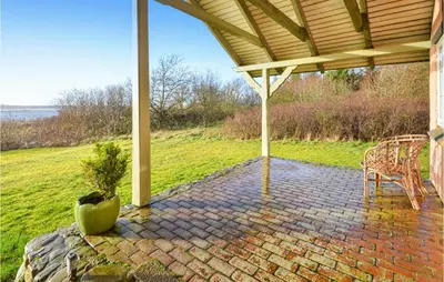 a pavilion with a table and chairs on a brick patio at Cozy Home In Thyholm With Wifi in Thyholm