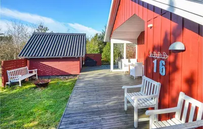 a deck with two chairs and a red building at Nice Home In Hurup Thy in Sønder Ydby