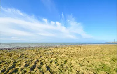 a beach with lots of grass and the ocean at Nice Home In Hurup Thy in Sønder Ydby