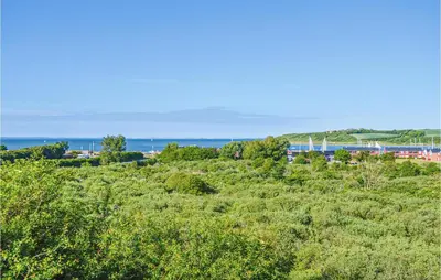 a field of grass with the ocean in the background at Lovely Apartment In Lemvig With Kitchen in Lemvig