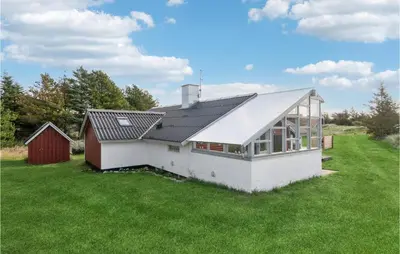 a white house with a metal roof on a green field at Amazing Home In Thisted With Wifi in Thisted