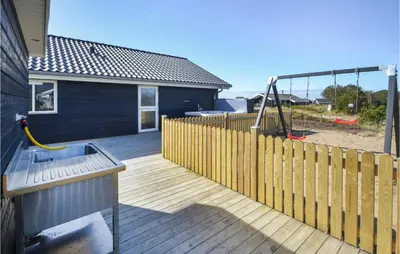 a wooden deck with a fence and a house at Amazing Home In Thisted With Sauna in Thisted