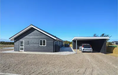 a house with a car parked in a garage at Amazing Home In Thisted With Sauna in Thisted