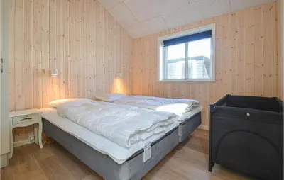 a bedroom with a bed and a window and a television at Amazing Home In Thisted With Sauna in Thisted