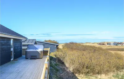a grill on a wooden deck next to a house at Amazing Home In Thisted With Sauna in Thisted