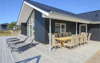 a wooden deck with a table and chairs on it at Amazing Home In Thisted With Sauna in Thisted