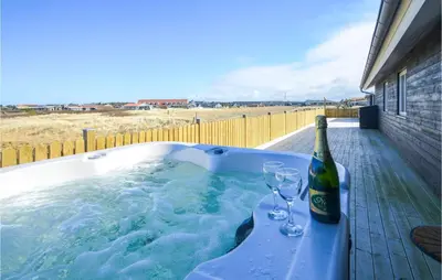 a hot tub with a bottle of wine and two glasses at Amazing Home In Thisted With Sauna in Thisted