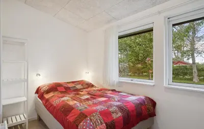 a bedroom with a bed and two windows at Cozy Home In Hjerm With Kitchen in Hjerm