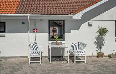two chairs and a table on a patio at 4 Bedroom Gorgeous Home In Blokhus in Blokhus