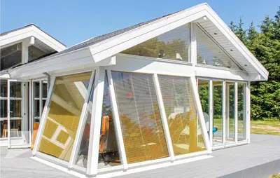 an orangery with sliding glass doors on a deck at Villa Mormor in Løkken