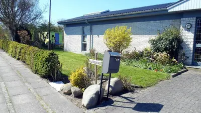 a street sign in a garden next to a house at Enkeltværelse in Vestervig