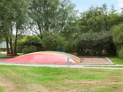 a colorful tent in a park next to a bench at 5 person holiday home on a holiday park in Lemvig in Lemvig