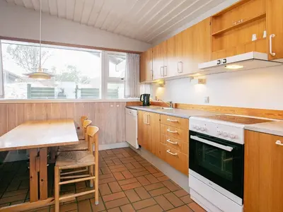 a kitchen with a table and a stove top oven at Seaside escape in Hanstholm in Hanstholm