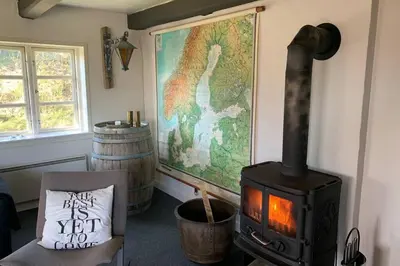 a room with a wood stove and a map on the wall at Thatched Holiday Home in Struer, Jutland with a view in Struer