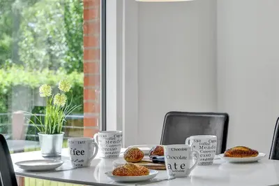 a table with cups and plates of food on it at Thatched Holiday Home in Struer, Jutland with a view in Struer