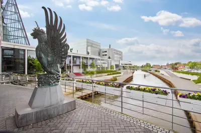 a statue of a bird on a sidewalk in a city at Marieshus in Holstebro