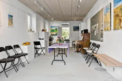 a dining room with a table and chairs in a room at Logi i hus med kunst og have in Vestervig