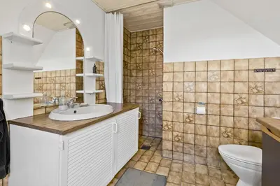a bathroom with a sink and a toilet at Logi i hus med kunst og have in Vestervig