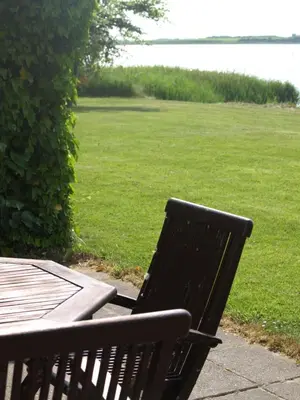 a black bench next to a table and a field at Skibstedgaard in Hurup