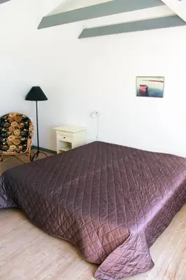 a large purple bed in a bedroom with a chair at Skibstedgaard in Hurup