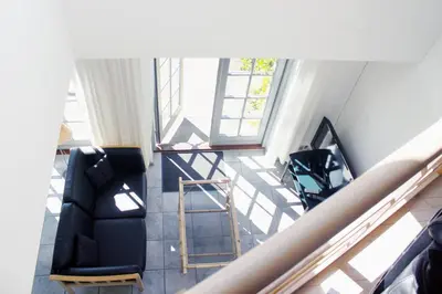 a living room with two chairs and a staircase at Skibstedgaard in Hurup
