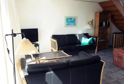 a living room with a couch and a table at Skibstedgaard in Hurup