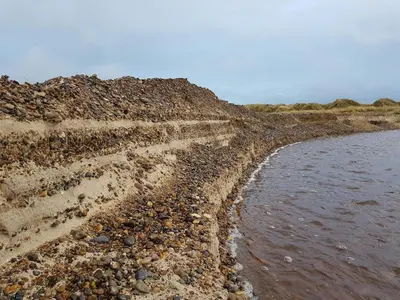 a muddy shore with rocks and the water at 6 person holiday home in Brovst in Brovst