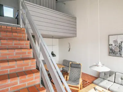 a room with a staircase and a chair and a table at 6 person holiday home in Brovst in Brovst