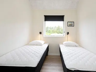two beds in a room with a window at 10 person holiday home in Thisted in Thisted